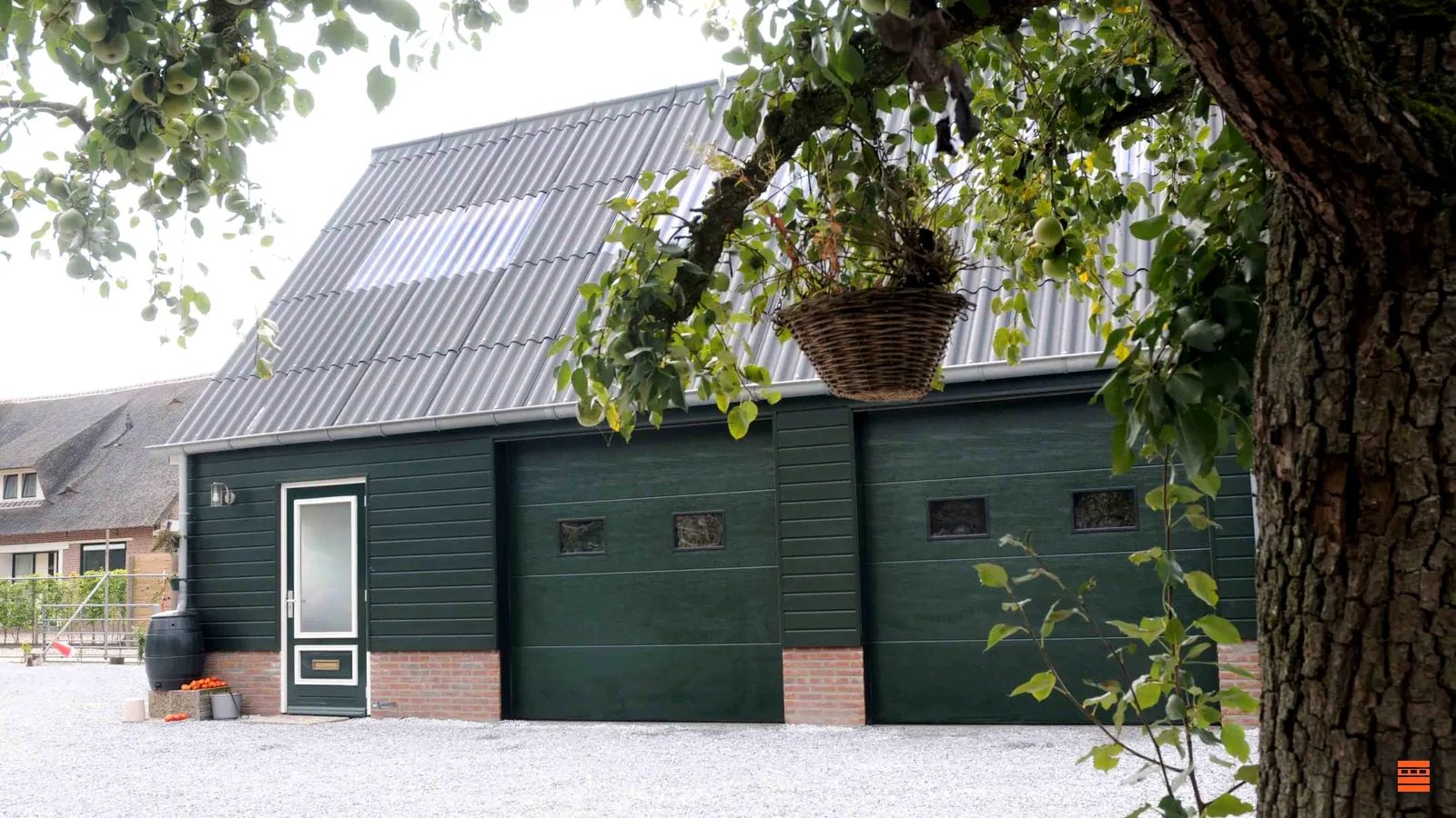 Portes de garage vertes à hublots sur une dépendance